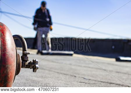 Roll Roofing Installation With Propane Blowtorch During Construction Works