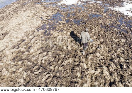 Man On A Treasure Hunt With A Metal Detector In The Woods On The Field, Photographed From A Drone, B