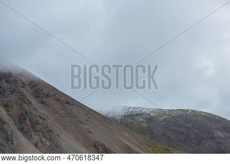 Dramatic Landscape With High Mountain Range In Rainy Low Clouds. Bleak Alpine Scenery With Mountain 