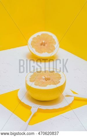 A Citrusy Grapefruit Pomelo On A Plate. Restaurant Room With Yellow Walls