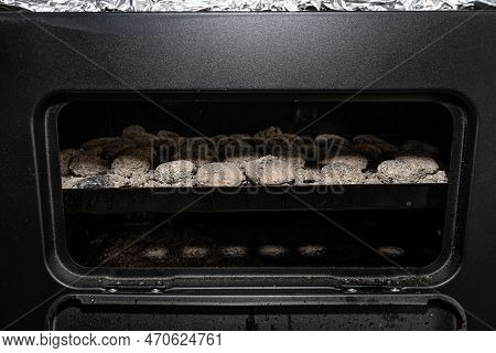 Cleaning A Dirty Grill While Standing On The Terrace And Emptying The Ashes.