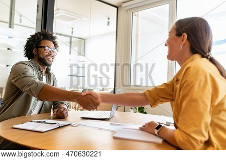 Handsome Positive Businessman Looking At The Female Colleague, They Shaking Hands. Collaboration Of 