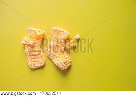 Yellow Knitted Child Socks. Handmade Wollen Socks On Yellow Background. Warm Winter Clothes For Baby