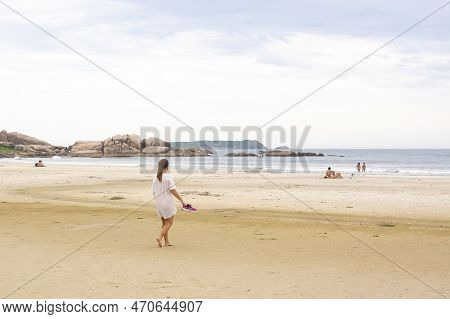 Florianopolis, Brazil - January 22, 2023 : A Girl Walks On The Beach Galheta, Florianopolis, Brazil.