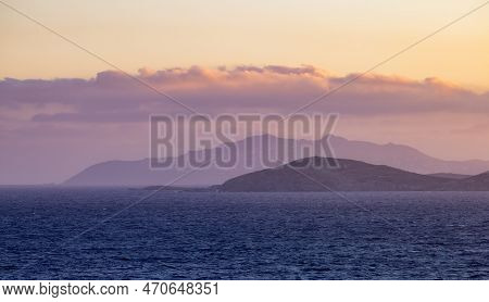 Rocky Island On Mediterranean Sea. Rinia Near Mikonos, Greece, Europe. Nature Background. Sunrise Sk