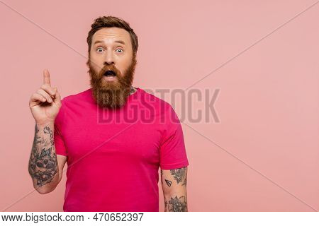 Astonished Tattooed Man Showing Idea Gesture While Standing With Open Mouth Isolated On Pink.