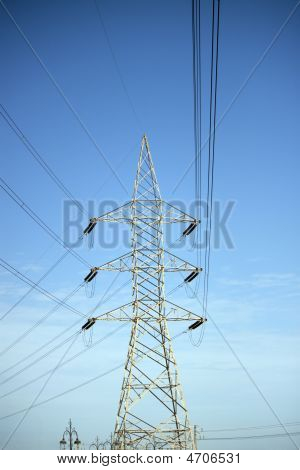 Power Mast med kabler og blå himmel som baggrund