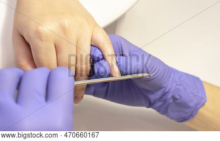 Manicurist Shapes, Files Beautiful Womans Nails, Holding Finger. Caucasian Manicure Master Works In 
