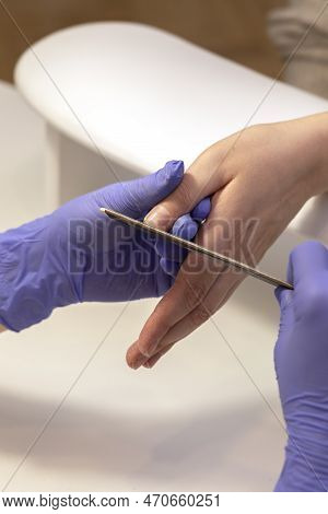 Manicurist Shapes, Files Beautiful Womans Nails, Holding Finger. Caucasian Manicure Master Works In 