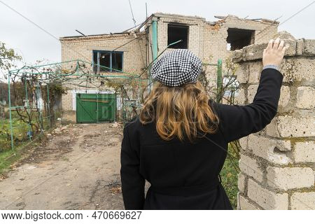 Countryside. Girl Looks At The House Destroyed By Shelling. War In Ukraine. Russian Invasion Of Ukra
