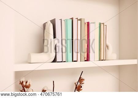 Beautiful Hand Shaped Bookends With Books On Shelf Indoors