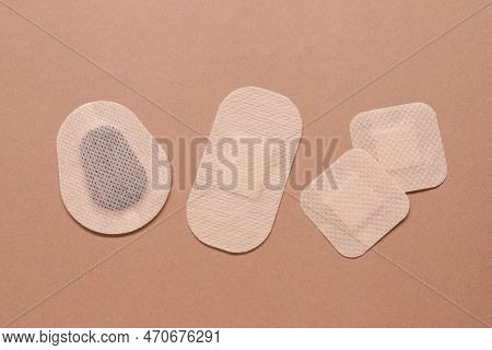 Different Contraceptive Patches On Light Brown Background, Flat Lay