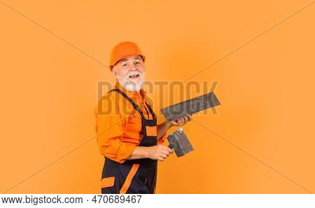 Plaster Trowel Spatula On Yellow Drywall Plasterboard. Plasterer In Working Uniform Plastering. Man 