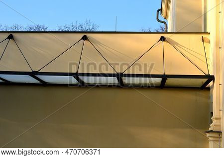 Glass Shelter By A Beige Historical Building. Attached To The Facade Of The Wall In A Metal Frame Su