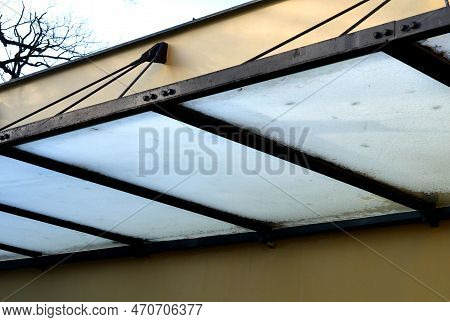Glass Shelter By A Beige Historical Building. Attached To The Facade Of The Wall In A Metal Frame Su