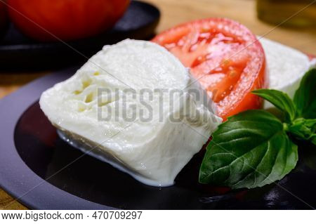 Sliced White Ball Of Italian Soft Cheese Mozzarella Di Bufala Campana Served With Fresh Green Basil