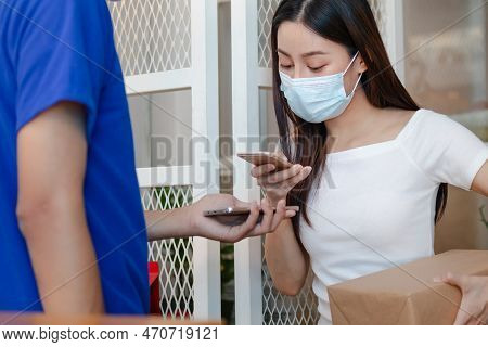 Young Asian Woman,client Wearing Face Mask And Use Mobile Scan Accept A Delivery Of Baggage, Cardboa