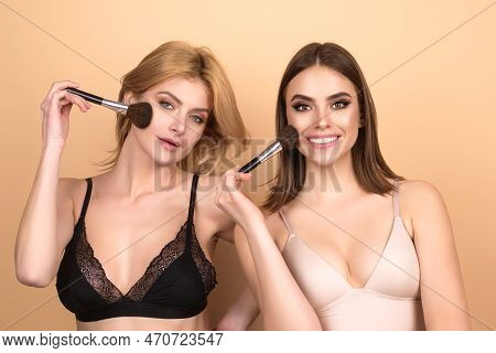 Two Sexy Girls Hold Blush Blusher Apply Powder Visage Isolated Over Studio Background. Young Friends