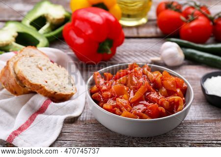 Bowl Of Delicious Lecho And Ingredients On Wooden Table
