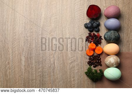 Naturally Painted Easter Eggs And Space For Text On Wooden Table, Flat Lay. Beetroot, Blueberries, H