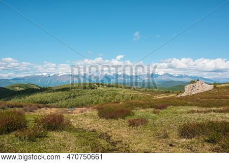 Atmospheric Landscape With Big Rock On Hill With View To Sunlit Mountain Vastness And High Snowy Mou