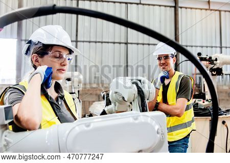 Female Electrician Working Robotic Arm Taking Break, Calm And Concentrating While Male Architect Fri