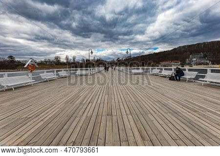 Gdynia, Poland - April 2022: Beautiful Long Wooden Pier With Lamps On Both Sides And Walking People