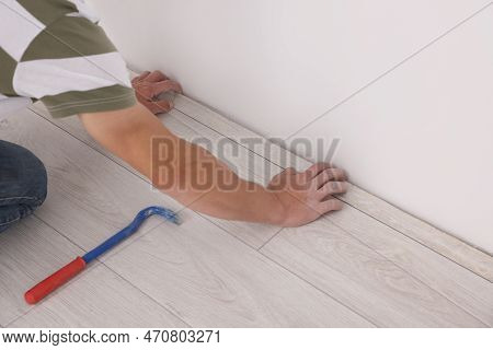 Professional Worker Using Nail Puller During Installation Of New Laminate Flooring Indoors, Closeup