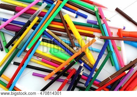 A Bunch Of Bright Felt-tip Pens And Pencils Lie On A White Background.
