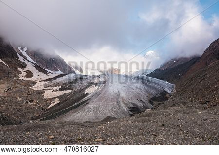 Scenic Mountain Landscape With Large Glacier In Low Clouds In Sunrise Colors. Colorful View To Glaci