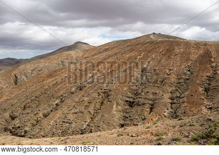 Shapes And Lines Of The Mountains Of The Volcanic Origin. Light Brown Color Of The Soil. Sky With Cl