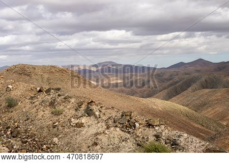 Shapes And Lines Of The Mountains Of The Volcanic Origin. Light Brown Color Of The Soil. Sky With Cl