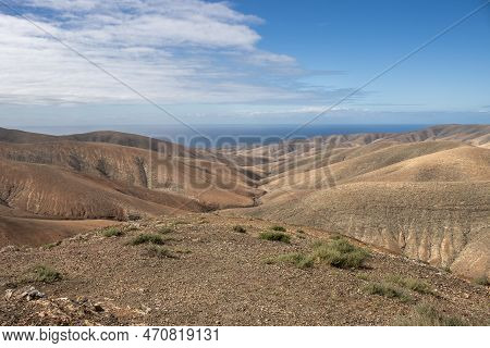 Shapes And Lines Of The Mountains Of The Volcanic Origin. Light Brown Color Of The Soil. Sky With Cl