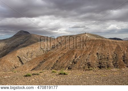 Shapes And Lines Of The Mountains Of The Volcanic Origin. Light Brown Color Of The Soil. Sky With Cl