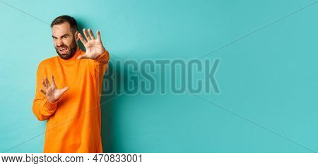 Disgusted Man Cringe And Extending Hands In Protection, Begging For Mercy, Looking At Something With