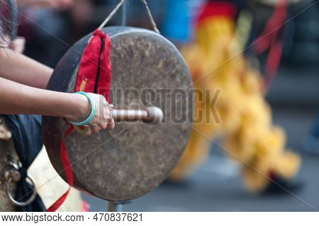 Musician Playing With A Gong During The Guan Di Festival.
