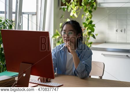 Self-education. Smiling Young Asian Woman Sitting At Kitchen Table With Computer Exploring Free Educ