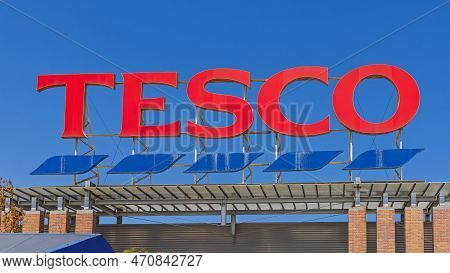 Szeged, Hungary - August 01, 2022: Large Tesco Supermarket Red Sign Over Blue Sky Shopping Mall.