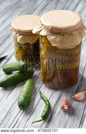 Pickled Cucumbers In A Jar With Kraft Lids , Fresh Gherkins, Garlic, Hot Pepper Chili On A Wooden Ba