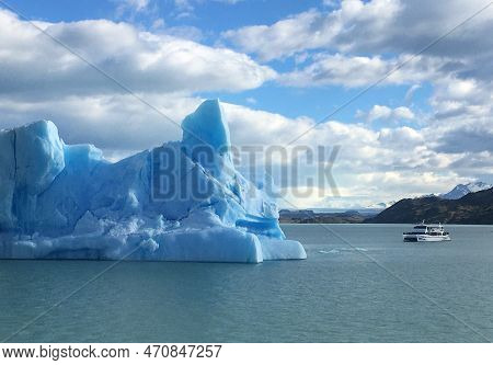 Small Tourist Boat Next To A Blue Iceberg Formed By Glaciers On A Frosty Summer Day In El Calafate I