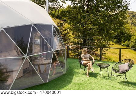 Transparent Bubble Tent At Glamping, Lush Forest Around And Interior. Woman Resting In Glamping