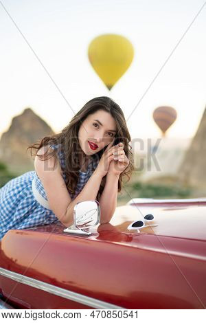 Beautiful Girl In Retro Style Posing Near A Vintage Red Cabriolet Car On Background Of Balloons In C