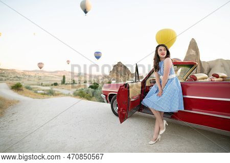 Beautiful Girl In Retro Style Posing Near A Vintage Red Cabriolet Car On Background Of Balloons In C