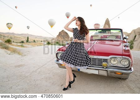 Beautiful Girl In Retro Style Posing Near A Vintage Red Cabriolet Car On Background Of Balloons In C