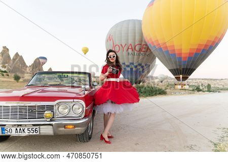 Goreme, Turkey, Cappadocia- June 30, 2021: \\n Beautiful Girl In Retro Style Posing Near A Vintage R