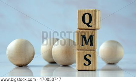 Qms (quality Management System) - Acronym On Wooden Cubes On The Background Of Light Balls. Selfishn