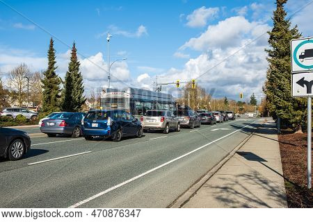 Traffic Driving Across The City. Traffic Jam In The Street, Cars Moves On A City Road On A Sunny Day