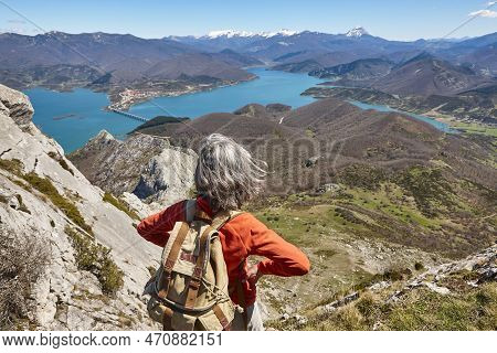 Picturesque Reservoir And Mountain Range Landscape In Riano. Hiker. Spain