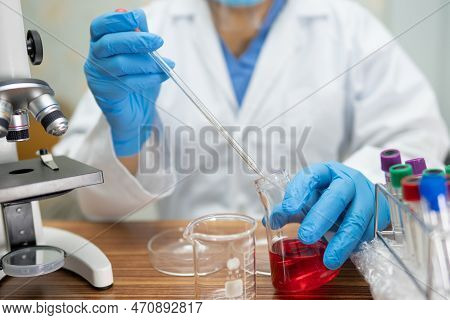 Scientist Holding Erlenmeyer Flask, Conical Flask Glassware With Red Color Liquid Solution In Scienc