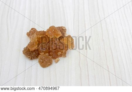 Palm Sugar Or Tal Mishri Isolated On White Wooden Background With Copy Space, Also Known As Rock Sug